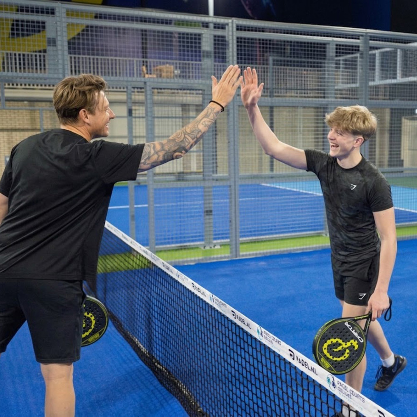 Padelspelers geven high five na een wedstrijd op padelbanen Groningen tijdens de padelladder in Zuidbroek