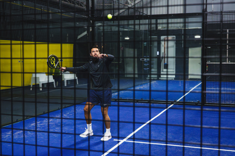 Een padel speler op de padelbaan in Nijmegen die aan een bal aan het smashen