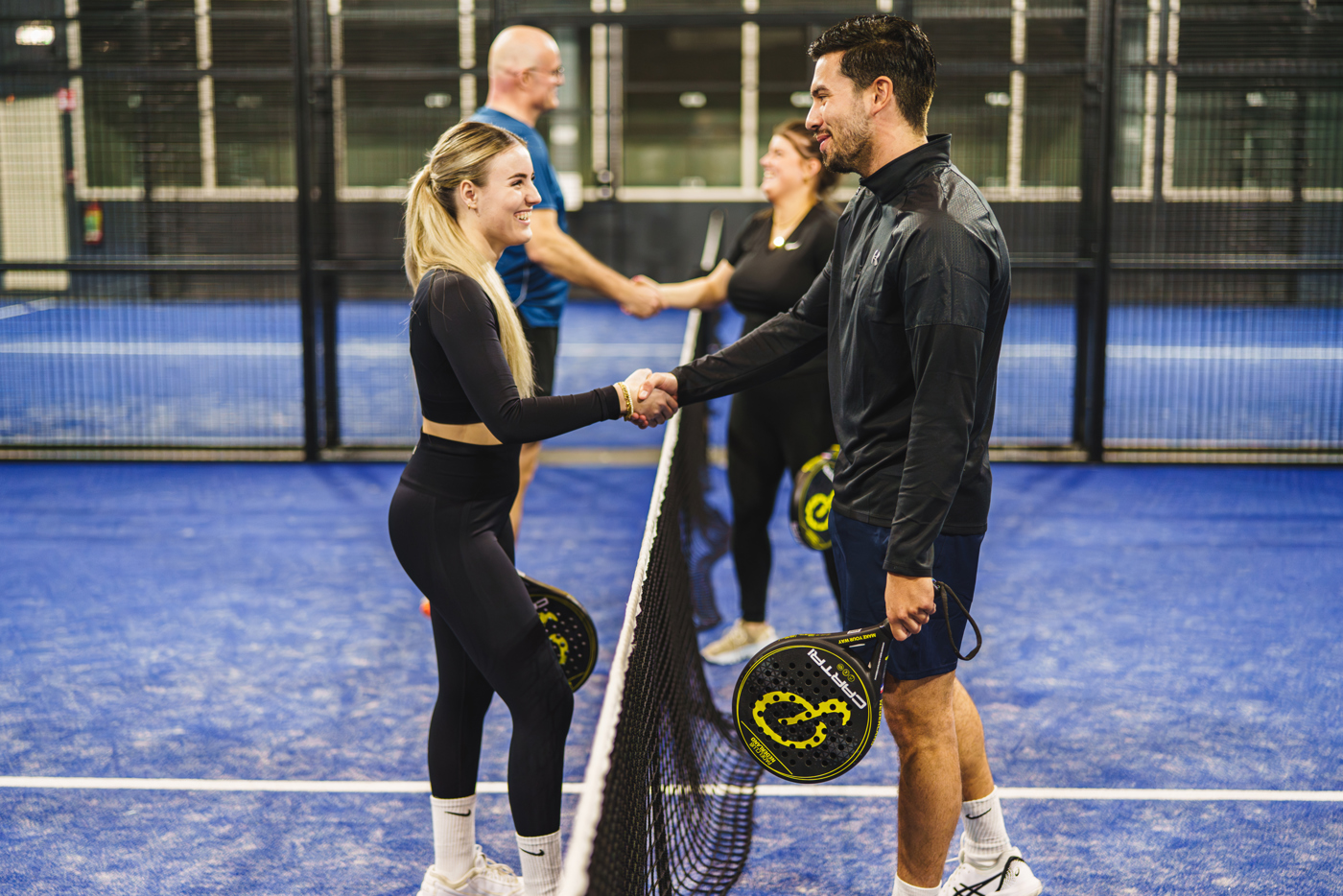 Vier padel spelers die elkaar feliciteren op de padel baan in Nijmegen