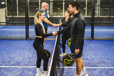 Vier padel spelers die elkaar feliciteren op de padel baan in Nijmegen