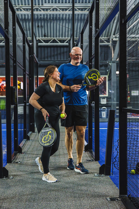 Twee padelspelers lopen de indoor padelbanen in Nijmegen binnen.