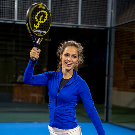 Padelspeler die de bal slaat op een indoor padelbaan vlakbij Meppel